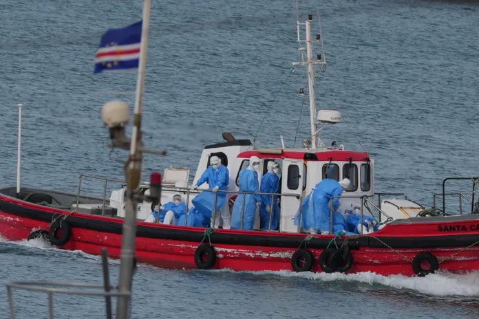Health workers in protective gear arrive to evacuate patients from the MV Hondius cru