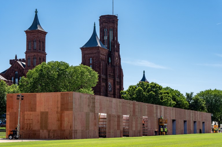 Work continues on a pavilion for the America 250 celebration on the National Mall with the Smithsonian Castle in the background, Tuesday, May 12, 2026, in Washington. (AP Photo/Alex Brandon)