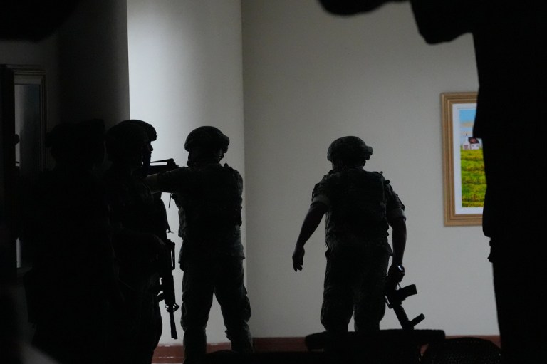 Philippine troopers exchange fire along a hallway at the Philippine Senate