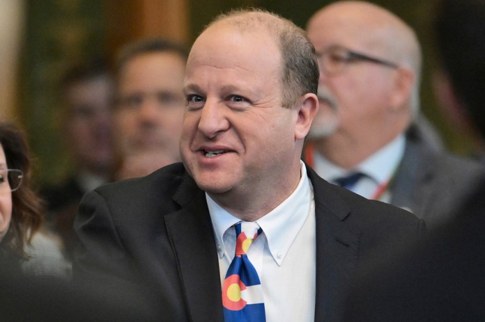 Jared Polis protests censure by showing up to Colorado Democrats’ call with taped mouth