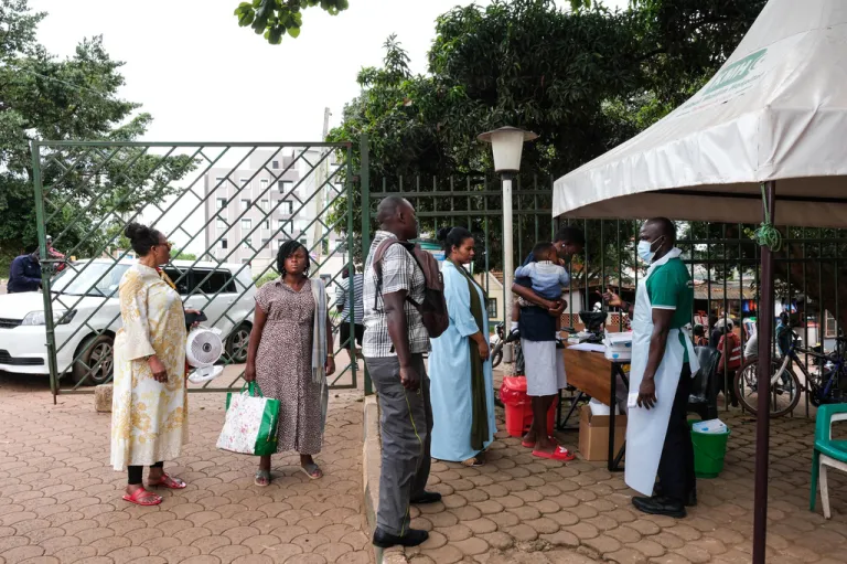 People wait to have their temperature taken in Kampala, Uganda, on May 16, 2026.