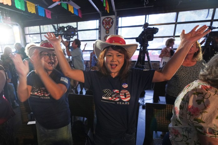 Melinda Tran, right, and Mimi Liter cheer after an endorsement announcement for Texas Attorney General Ken Paxton, a Republican candidate for the U.S. Senate, at a campaign event in McKinney, Texas, Tuesday, May 19, 2026. (AP Photo/LM Otero)