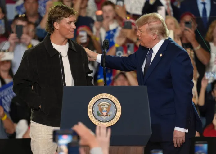 NFL quarterback Jaxson Dart, with the New York Giants, left, introduces President Donald Trump during a Fighting For American Workers event.
