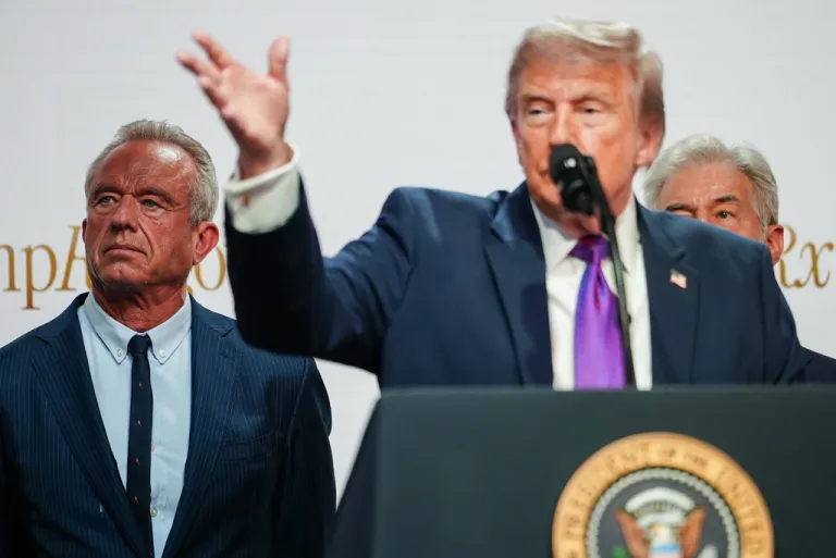 Health and Human Services Secretary Robert F. Kennedy Jr. and Centers for Medicare & Medicaid Services administrator Dr. Mehmet Oz watch as President Donald Trump speaks to reporters during an event on prescription drug prices in the South Court Auditorium of the Eisenhower Executive Office Building, Monday, May 18, 2026, on the White House campus in Washington. (AP Photo/Julia Demaree Nikhinson)