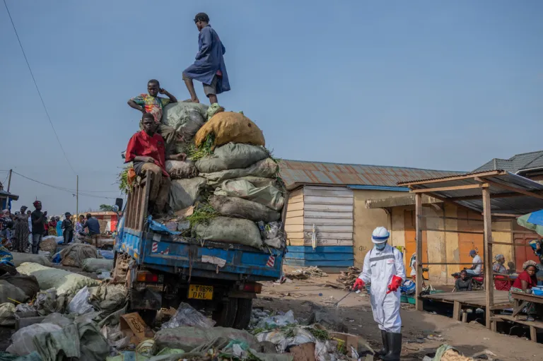 A sanitation worker from Bunia city government sprays disinfectant in the central market area near a rubbish truck in Ituri province, as they continue efforts to combat the Ebola outbreak in Bunia, the capital city of Ituri province in Congo, Saturday, May 23, 2026.