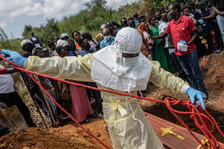 Red Cross workers prepare a coffin containing the body of a Ebola victim for burial at the Rwampara Cemetery, in Bunia, Congo, Saturday, May 23, 2026. (AP Photo/Moses Sawasawa)