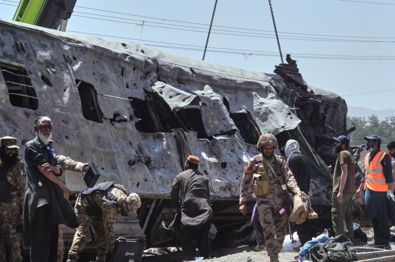 Security officials examine a damaged train coach on a railway track at the site of bomb explosion, in Quetta, Pakistan, Sunday, May 24, 2026. (AP Photo/Arshad Butt)