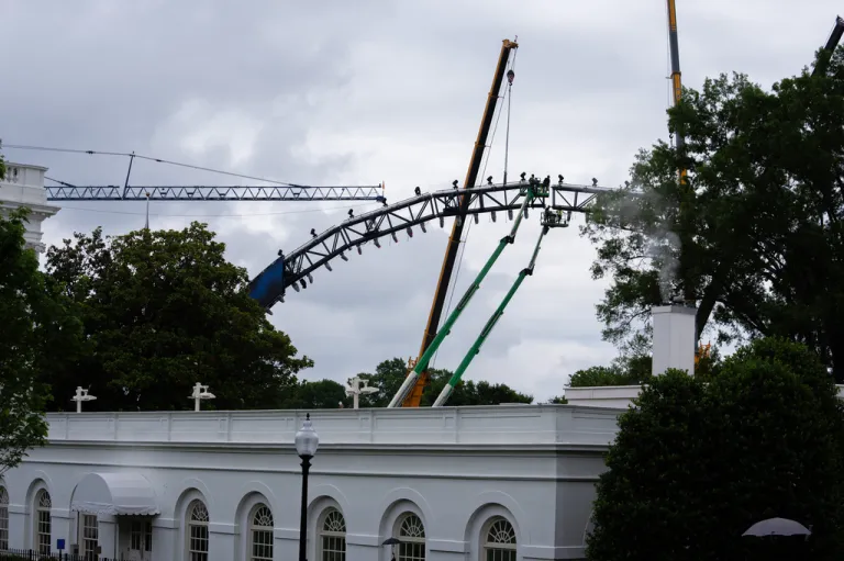 Crews work on the UFC fighting ring on the South Lawn of the White House