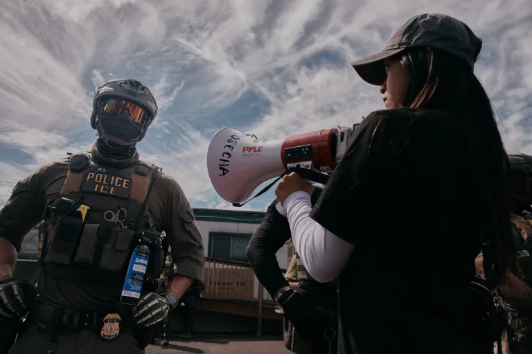 A protester plays music in front of a masked ICE agent outside the Delaney Hall detention during a protest against the transfer of detainees on Tuesday, May 26, 2026, in Newark, N.J. (AP Photo/Andres Kudacki)