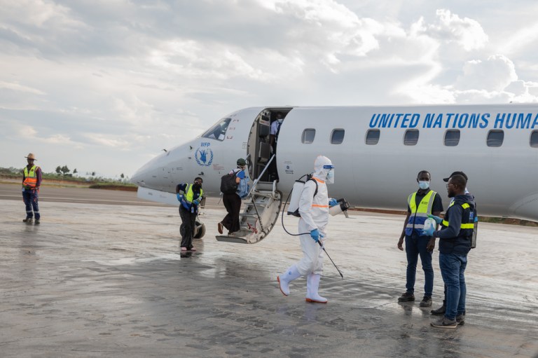 A health worker disinfects the airport near the World Food Programme's (WFP) aircraft following the government's announcement of Bunia National Airport's reopening in Bunia, Congo, Tuesday, June 2, 2026. (AP Photo/Moses Sawasawa)