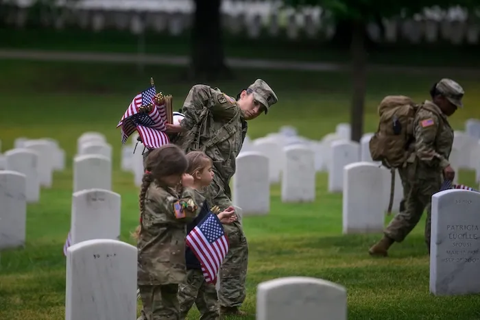 1st. Sgt. Kosovare Fain walks with her daughters at Arlington National Cemetery.
