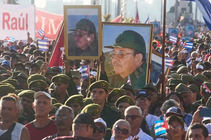 Members of the Revolutionary Armed Forces carry portraits of former President Raul Castro during a rally in his support in front of the U.S. Embassy in Havana, Cuba, Friday, May 22, 2026, after U.S. prosecutors filed an indictment accusing him of ordering the 1996 shootdown of civilian planes flown by Miami-based exiles. (AP Photo/Ramon Espinosa)