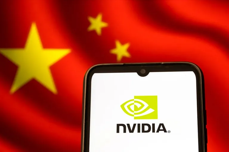 The Nvidia logo appears on a smartphone screen, and the flag of China displays as the background on a laptop computer screen in this photo illustration in Athens, Greece, on January 28, 2026. China gives the green light to three of its largest tech companies to buy Nvidia's H200 artificial intelligence chips, four people familiar with the matter tell Reuters, marking a shift in position as Beijing seeks to balance its AI needs against spurring domestic development. (Photo Illustration by