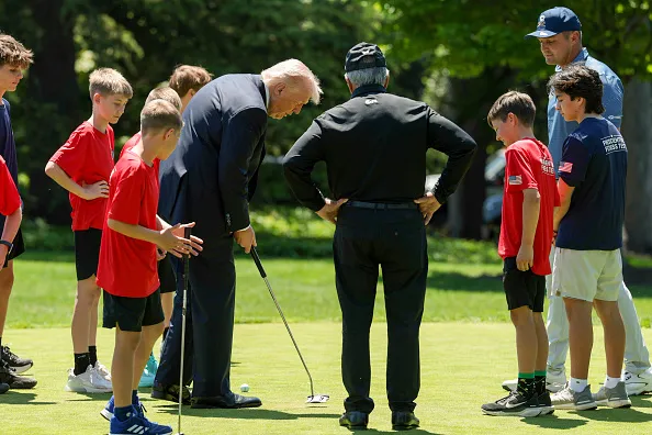 WASHINGTON, DC - MAY 05: U.S. President Donald Trump, professional golfer Bryson DeChambeau and retired professional golfer Gary Player golf with young athletes following a proclamation signing in the Oval Office of the White House on May 05, 2026 in Washington, DC. President Trump signed a presidential memorandum restoring the Presidential Fitness Test Award, which was reinstated by executive order in July 2025 and reintroduces a performance-based benchmark in physical education.
