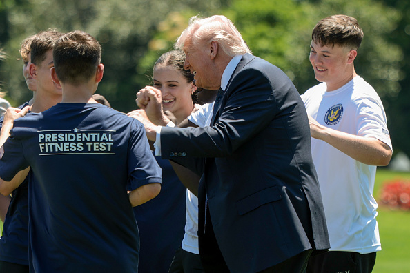 WASHINGTON, DC - MAY 05: U.S. President Donald Trump joins young athletes exercising following a proclamation signing in the Oval Office of the White House on May 05, 2026 in Washington, DC. President Trump signed a presidential memorandum restoring the Presidential Fitness Test Award, which was reinstated by executive order in July 2025 and reintroduces a performance-based benchmark in physical education.