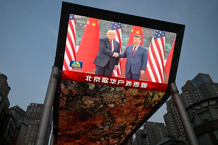 A big screen shows a broadcasting of Chinese President Xi Jinping meeting with US President Donald Trump at the Great Hall of the People in Beijing on May 14, 2026. (Photo by WANG Zhao / AFP via Getty Images)
