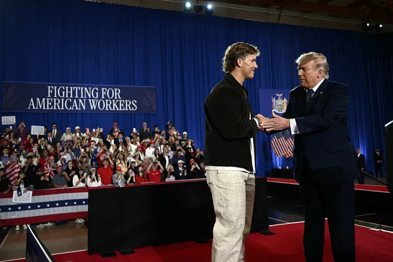 US President Donald Trump is welcomed by New York Giants quarterback Jaxson Dart before delivering a speech about the economy at Rockland Community College Fieldhouse in Suffern, New York, on May 22, 2026. Trump is the first sitting president to visit the northern New York City suburbs since Gerald Ford in 1976. (Photo by Brendan SMIALOWSKI / AFP via Getty Images)