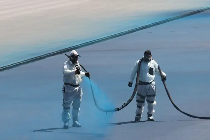 Workers spray blue lining on the Lincoln Memorial Reflecting Pool. (Photo by Graeme Jennings)