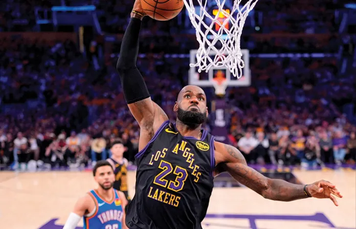 Los Angeles Lakers forward LeBron James dunks as Oklahoma City Thunder guard Ajay Mitchell watches during a second-round NBA basketball playoff game on May 11 in Los Angeles. (Mark J. Terrill/AP)