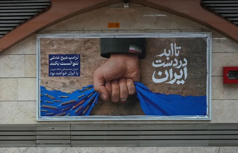 In an empty subway station, a billboard depicting a military hand gripping the Strait of Hormuz is displayed with Farsi text reading, “In Iran’s hands forever,” “Trump couldn’t do a damn thing,” and “Control of the Strait of Hormuz will be Iran’s forever,” in Tehran, Iran. (Vahid Salemi/AP)