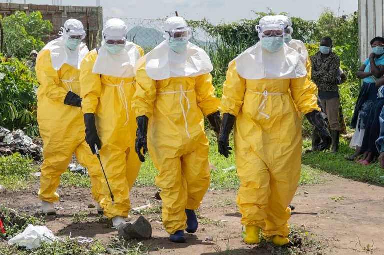 Red Cross workers arrive at a health center to transport people who died of Ebola, in Rwampara, Congo.