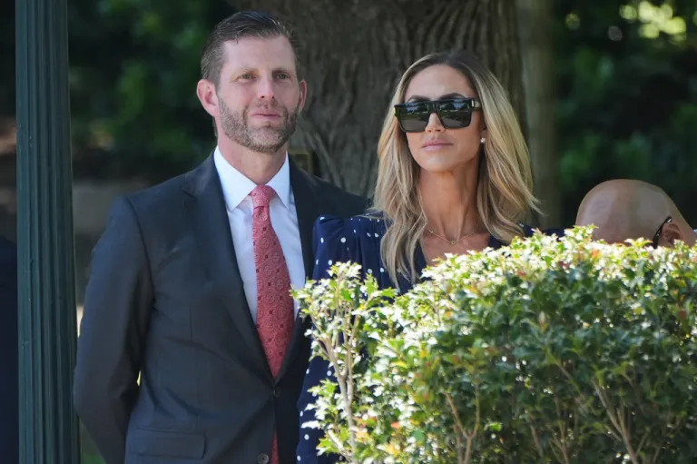 Eric and Lara Trump watch as President Donald Trump talks with reporters as he departs the White House for travel to Beijing.