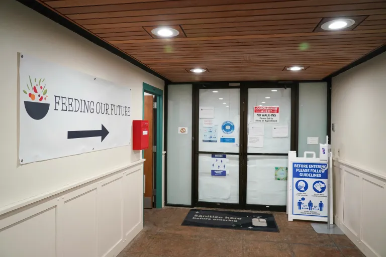 Building with a sign leading to Feeding our Future with an arrow leading to a door.