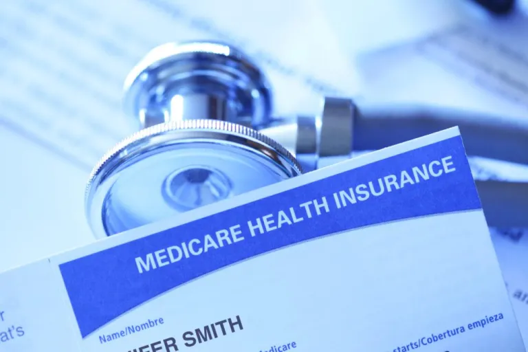 The top of a Medicare health insurance form is seen with a stethoscope behind it.