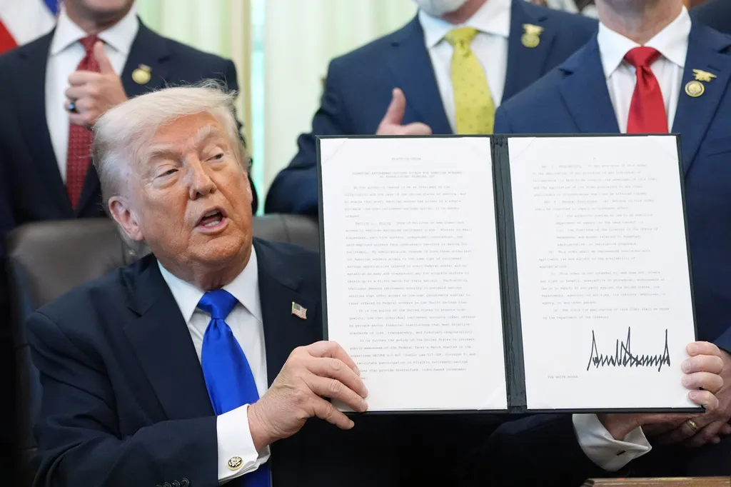 President Donald Trump holds up an executive order.