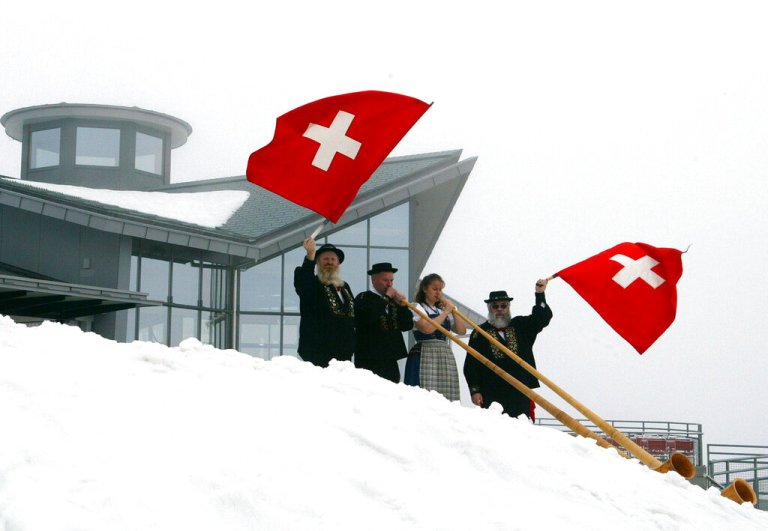 Waving Swiss flags and blowing alphorns, the folk group 