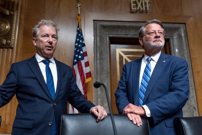 Sen. Rand Paul, R-Ky., left, the ranking member of the Senate Homeland Security and Governmental Affairs Committee, joins Chairman Gary Peters, D-Mich., for a hearing to examine origins of COVID-19, at the Capitol in Washington, Tuesday, June 18, 2024. (AP Photo/J. Scott Applewhite)