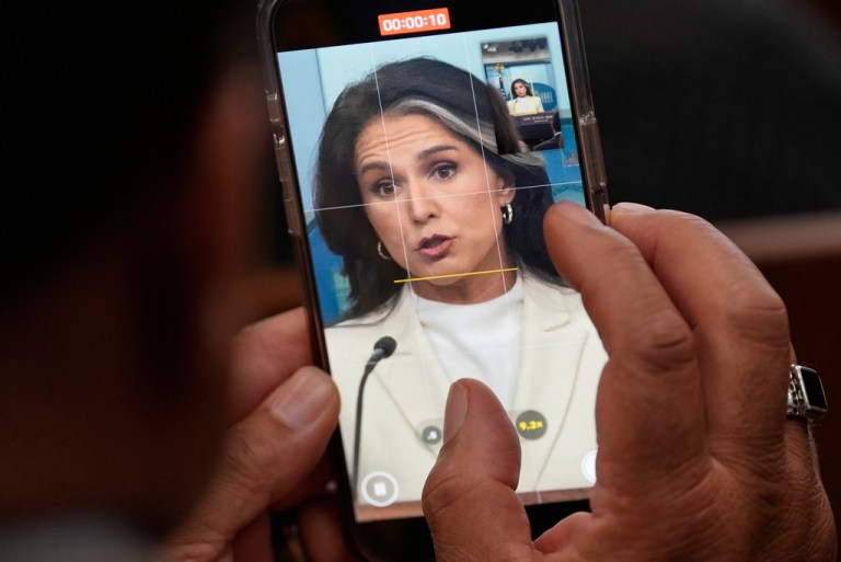 A reporter looks at a video as Director of National Intelligence Tulsi Gabbard speaks with reporters in the James Brady Press Briefing Room at the White House, Wednesday, July 23, 2025, in Washington. (AP Photo/Julia Demaree Nikhinson)
