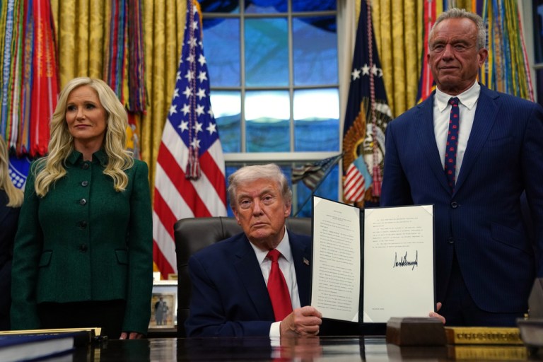 President Donald Trump holds a sign executive order on addiction recovery