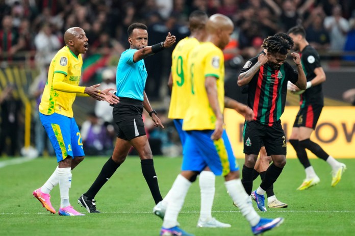 AS FAR Rabat's To Carneiro, right, reacts as the referee Omar Artan signals a penalty