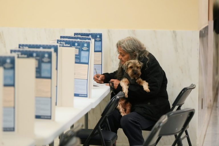 Carmen Sandoval holds her dog Peluche as she votes in the California primary election at City Hall on Tuesday, June 2, 2026, in San Francisco.