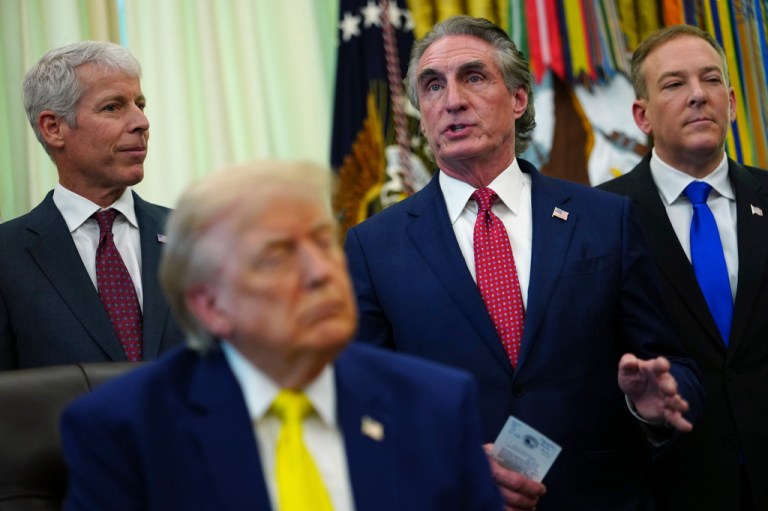 Interior Secretary Doug Burgum standing behind President Donald Trump
