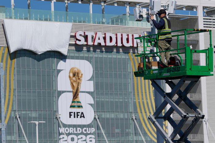 A worker gestures near the stadium as preparations continue, Thursday, June 11, 2026, in Santa Clara, Calif., near San Francisco, ahead of the World Cup Group B soccer match between Qatar and Switzerland.