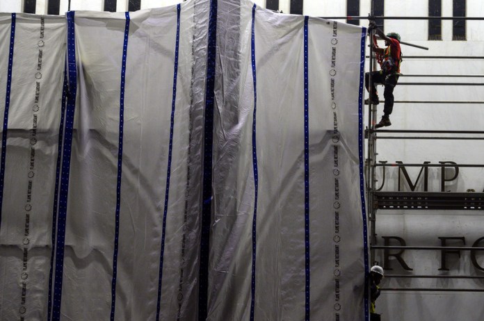 Workers install tarps on the scaffolding at the John F. Kennedy Center for the Performing Arts in Washington, Saturday, June 13, 2026.