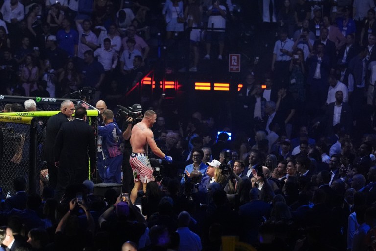 President Donald Trump, at right wearing a white hat, congratulates Justin Gaethje after he defeated Ilia Topuria in a lightweight title bout during UFC Freedom 250.