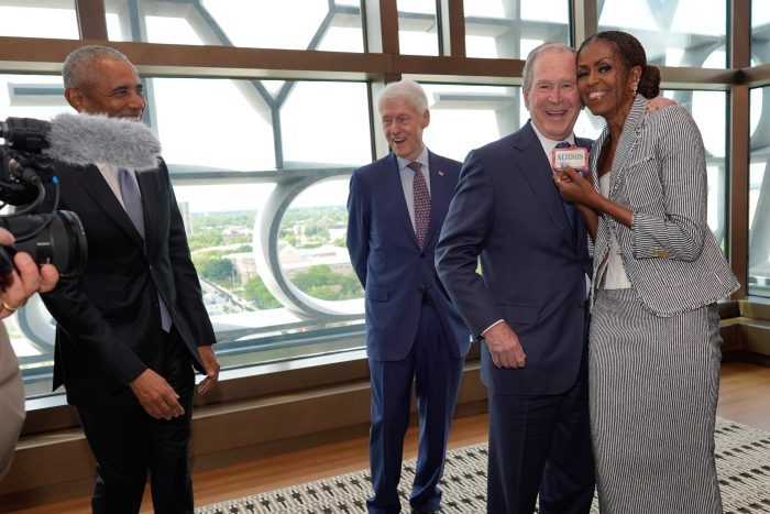 Former President Barack Obama and former President Bill Clinton watch as former President George W. Bush, gives former first lady Michelle Obama mints ahead of the dedication ceremony at the Obama Presidential Center, Thursday, June 18, 2026, in Chicago. (AP Photo/Pablo Martinez Monsivais, Pool)