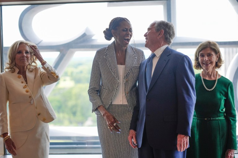 Former President George W. Bush laughs with former first lady Michelle Obama as former first lady Jill Biden and former first lady Laura Bush watch, ahead of the dedication ceremony of the Obama Presidential Center.