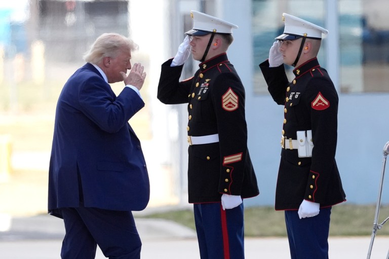 President Donald Trump, left, salutes as he walks to board Marine One