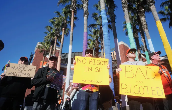 Protesters hold up signs in reaction to San Francisco Giants’ players recently writing on Pride hats outside of Oracle Park before a baseball game between the Giants and the Athletics on Tuesday, June 23, 2026, in San Francisco. (Jeff Chiu/AP)