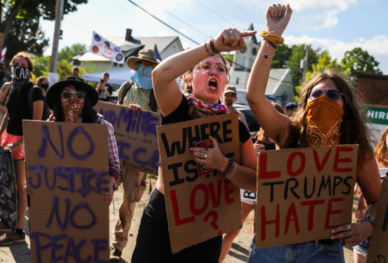Anti-Trump protestors Lilah McCormack, left, and her sister Lilli shout at trump supporters as they protest on a corner in Guilford, ME on June 5, 2020. President Donald Trump will make an official visit to medical manufacturing plant, Puritan Medical Product, in Guilford Friday afternoon. (Photo by Erin Clark/The Boston Globe via Getty Images)