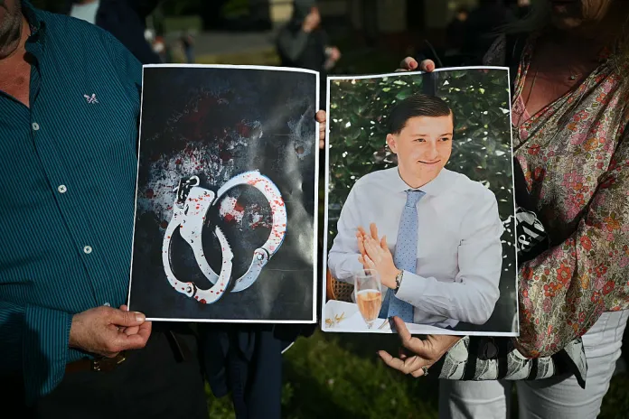 People hold images of victim Henry Nowak, and blood-covered handcuffs as they take part in a protest outside of Southampton Central Police Station in Southampton, southern England, on June 2, 2026, following the murder of Henry Nowak by Vickrum Digwa. Body camera footage of a dying student who was handcuffed by British police after being stabbed by a Sikh man and falsely accused of racially abusing his murderer sparked outrage Tuesday. (Photo by JUSTIN TALLIS / AFP via Getty Images)