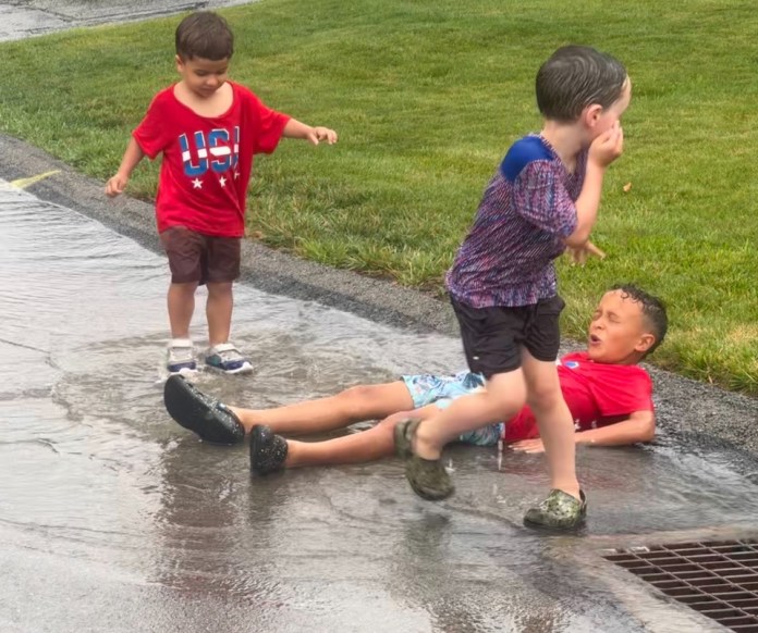 A sudden downpour didn't stop the children from enjoying their neighborhood's America 250 celebration. (Salena Zito)
