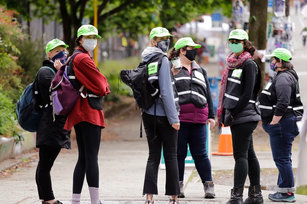 Legal observers from the National Lawyers Guild look on Sunday, June 28, 2020, in Seattle, where several streets are blocked off in what has been named the Capitol Hill Occupied Protest zone. Seattle Mayor Jenny Durkan met with demonstrators Friday after some lay in the street or sat on barricades to thwart the city's effort to dismantle the protest zone that has drawn scorn from President Donald Trump and a lawsuit from nearby businesses. (AP Photo/Elaine Thompson)