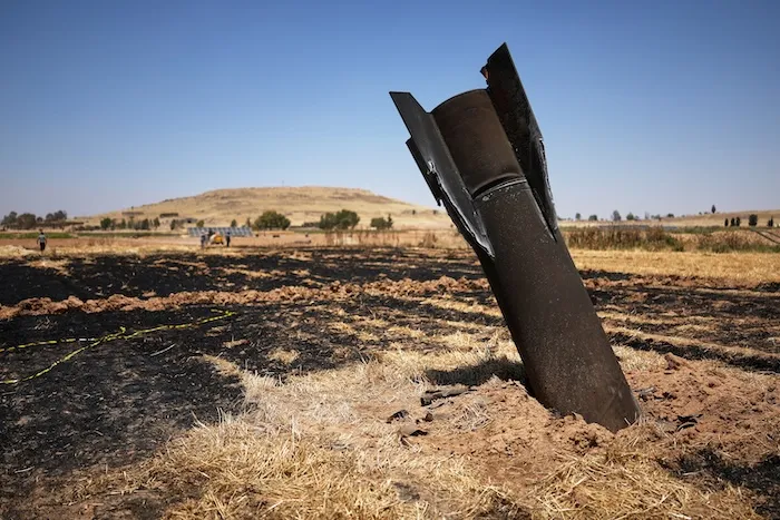 A projectile is seen in a burned agricultural field.