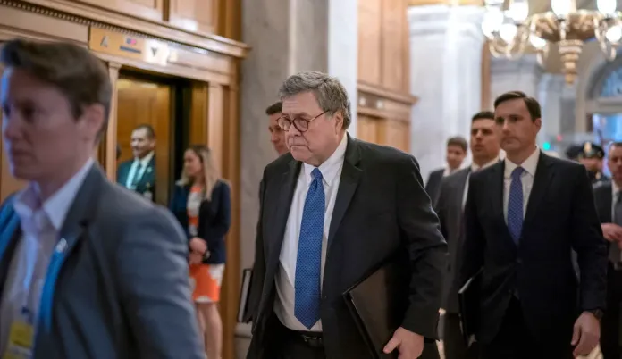 Bill Barr walks down a chamber hall.