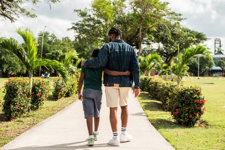 Young father and son walking while talk outdoors